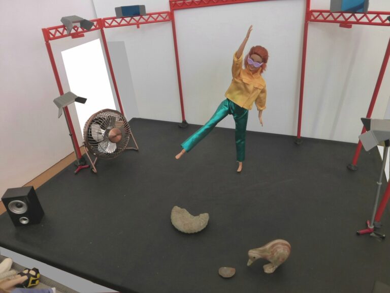 Doll dancing on a stage with objects