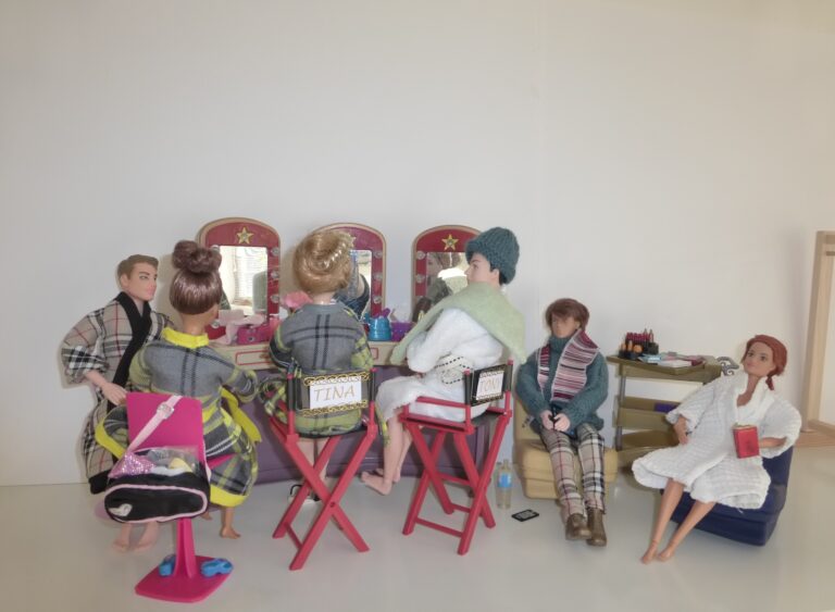 A group of dolls in a theatre dressing room setting